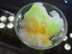 A bowl of shaved ice with a variety of syrup
